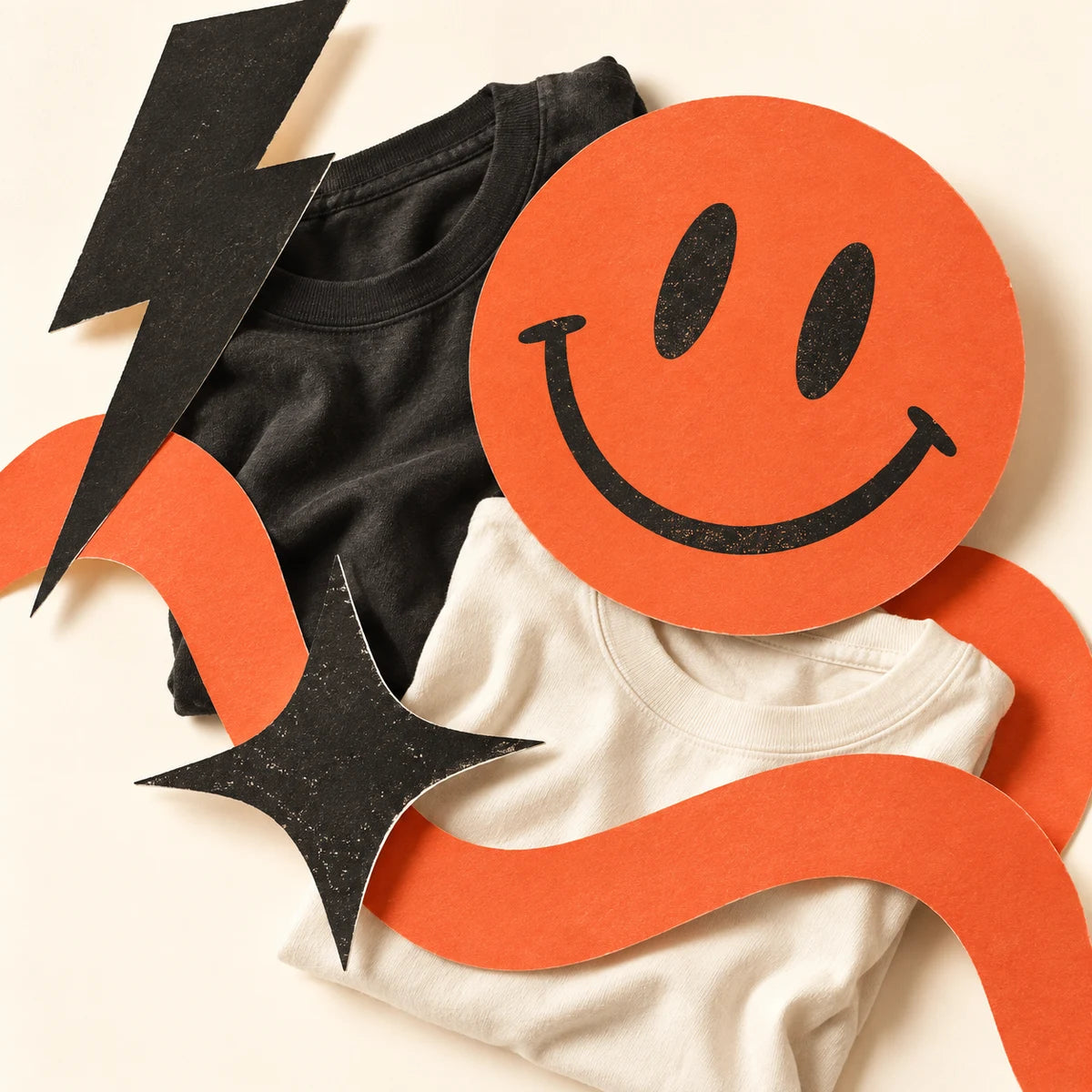 MoodRally brand collage with folded charcoal and cream T-shirts, a coral smile, lightning bolt, and star.